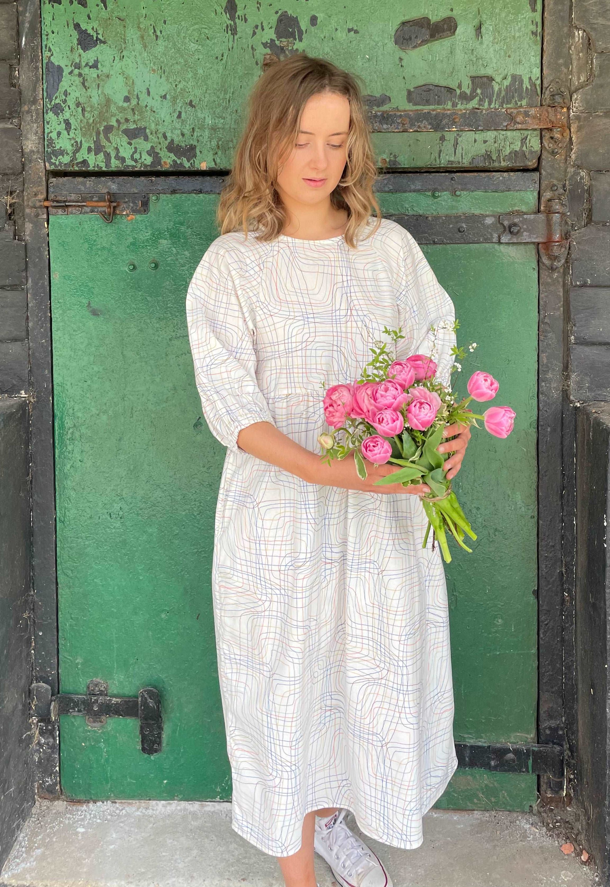 model wearing cream kay dress holding a bouquet