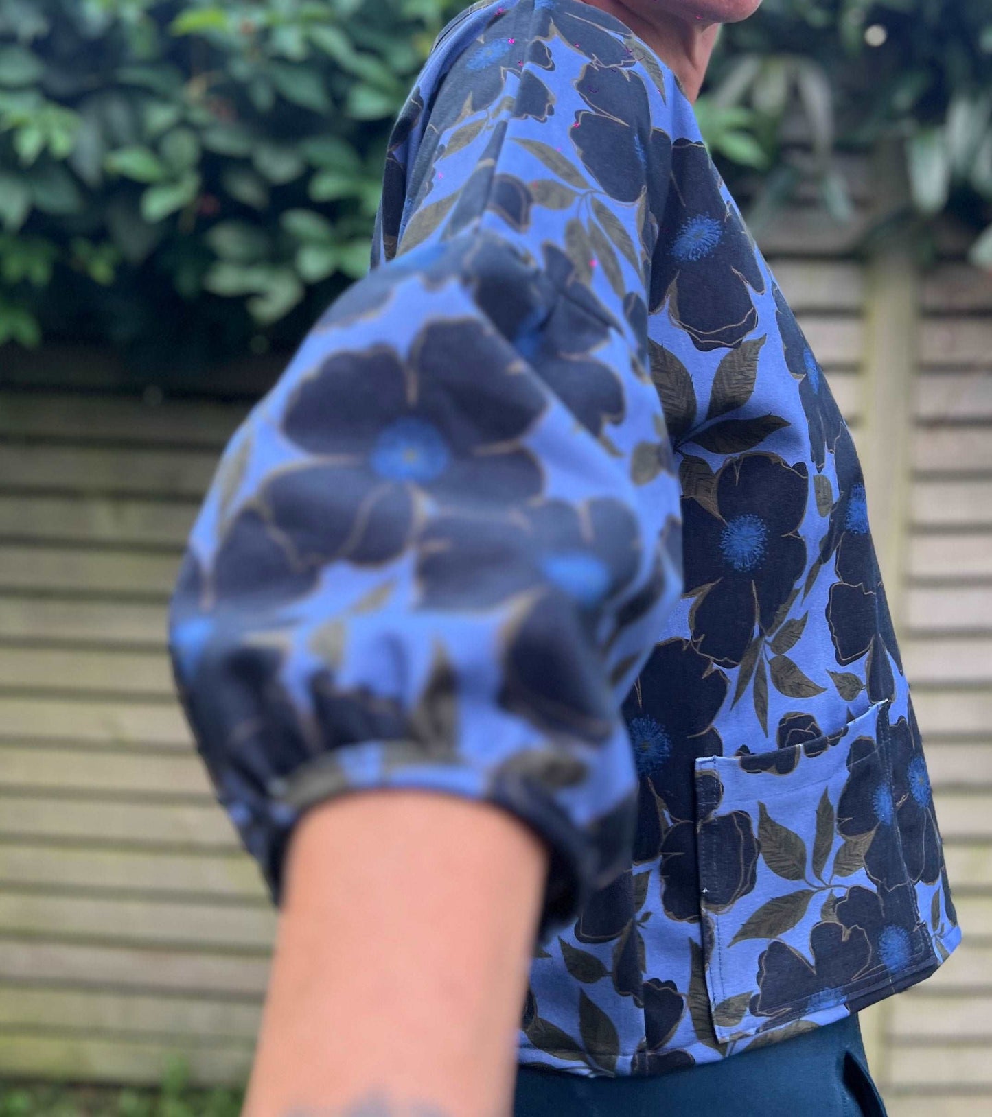 Close up of a cloud blouse sleeve in blue floral print