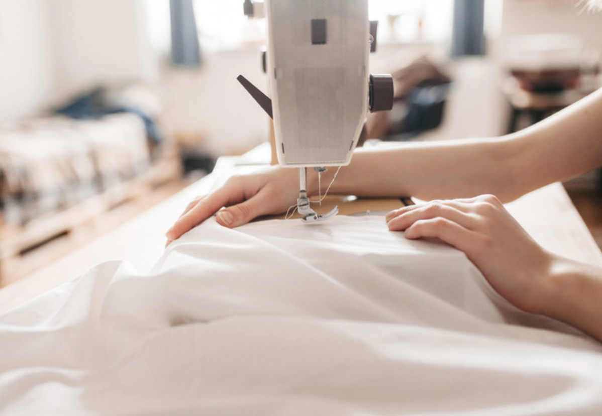 Hands sewing on a sewing machine