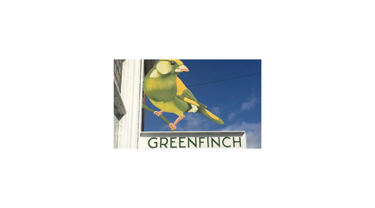 Greenfinch bird on a shop sign