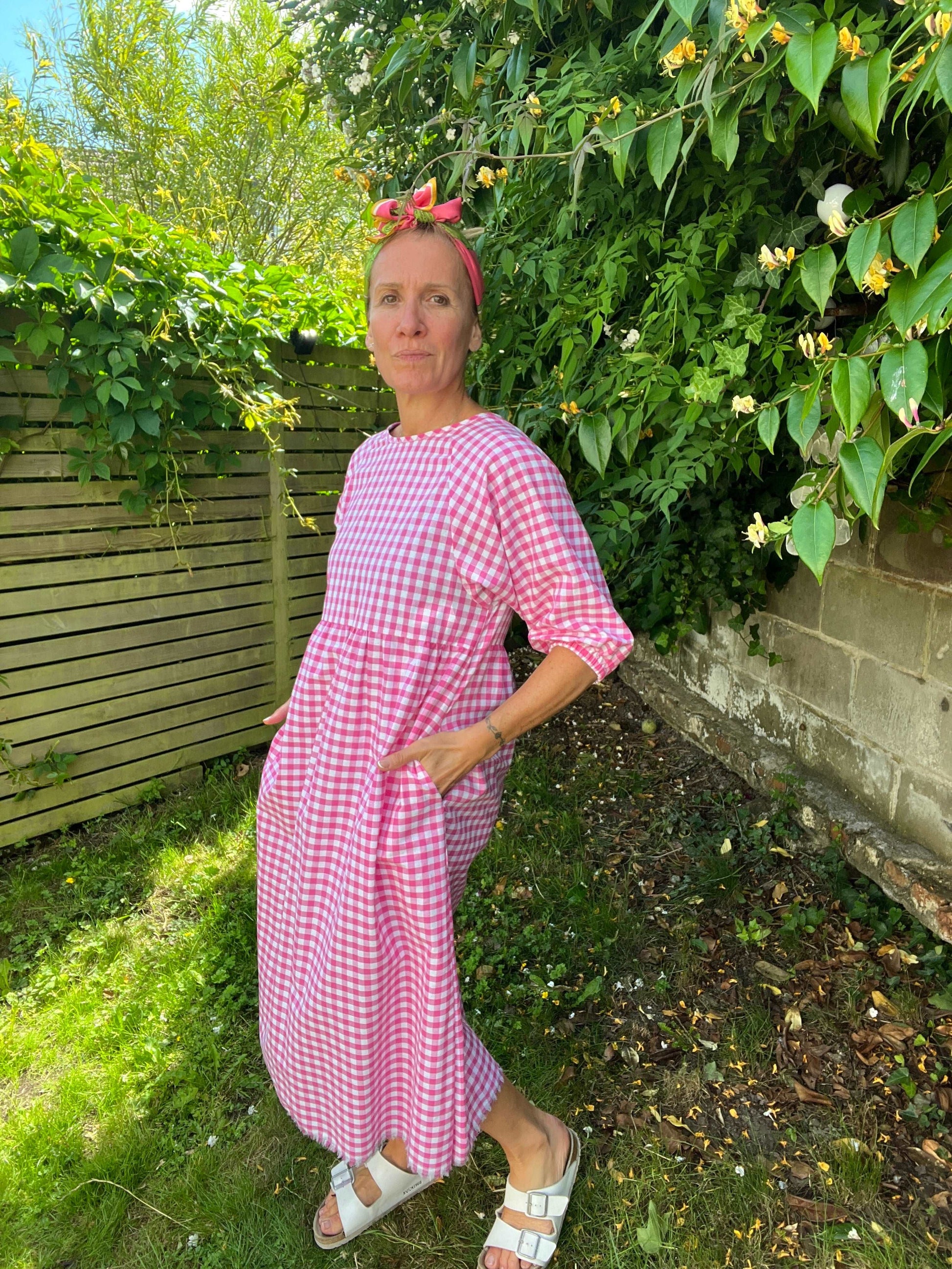 Model in pink gingham dress with pockets sustainable dresses UK