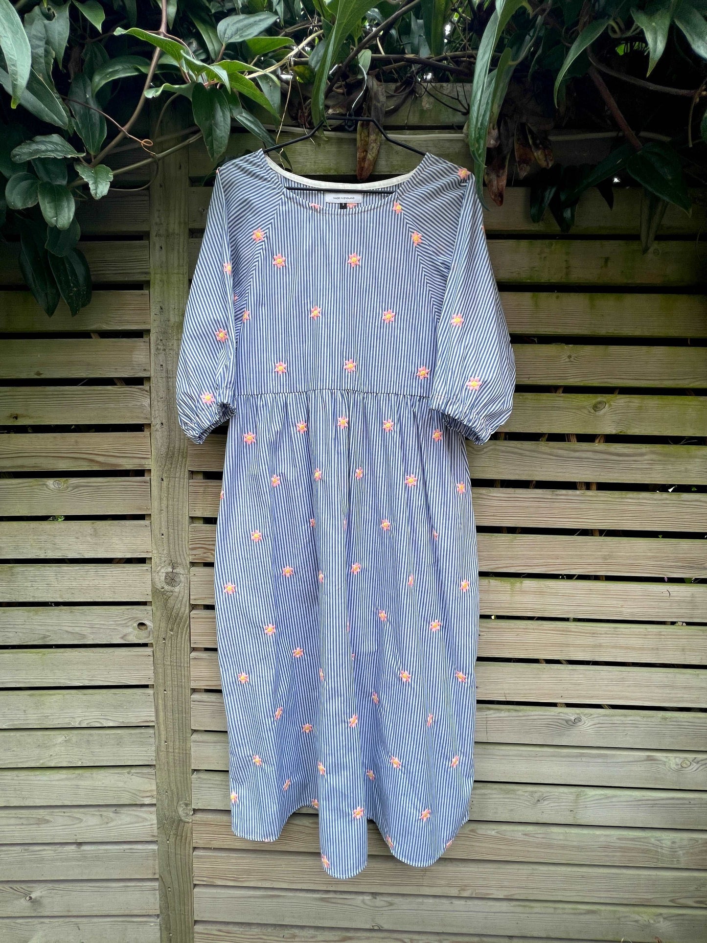Kay dress on indigo stripe and embroidered stars on a hanger