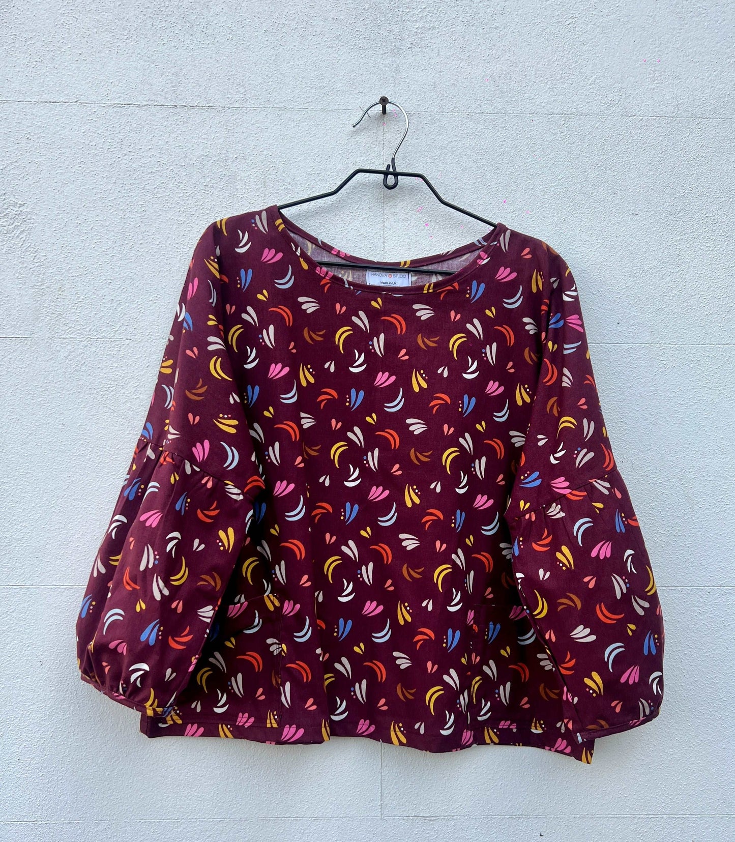 puff sleeve ethically made print blouse on a hanger
