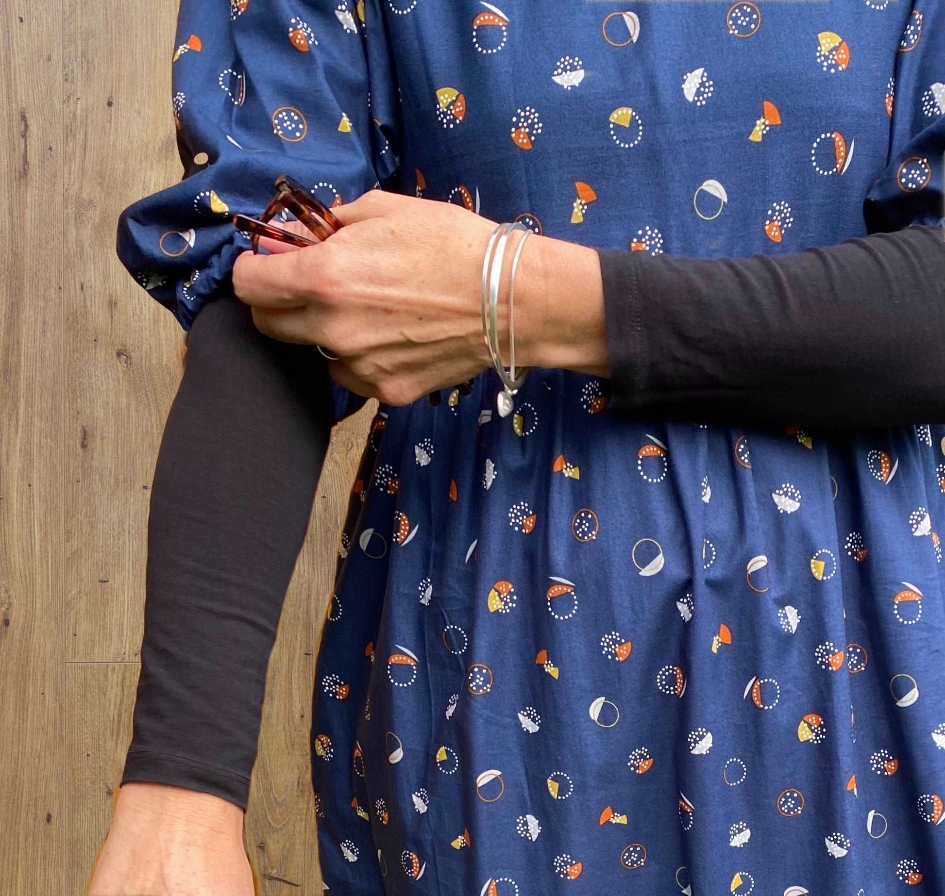 close up of kay dress in navy fizz holding sleeve sustainable dresses UK