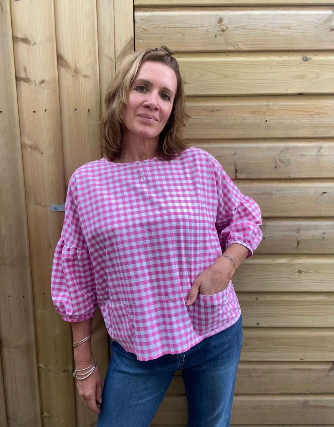 model wearing a pink gingham cloud blouse hand in pocket