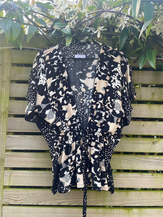 Angel tie front top in neutral print fabric on a hanger